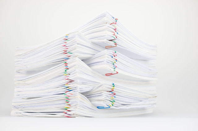 A criminal defense attorney examining legal documents related to government contract fraud case.